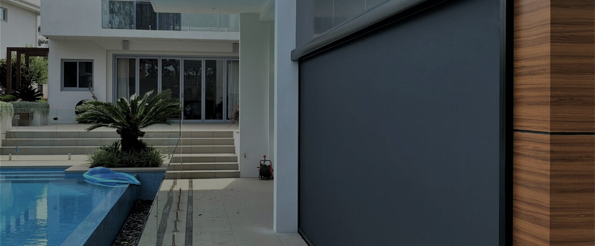 MagnaTrack hurricane screen deployed across a poolside lanai opening.